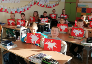 Zdjęcie przedstawia uczniów kl. Ib prezentujących prace plastyczne wykonane z okazji Święta Niepodległości.